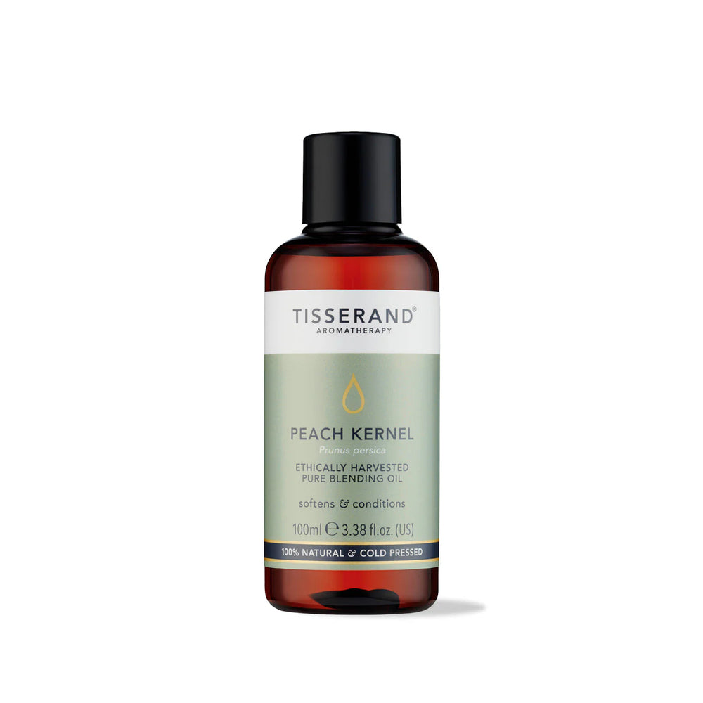 100ml amber glass bottle of Tisserand Peach Kernel oil with a sage green and white label and a black screw cap.