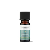 A small amber glass bottle of Tisserand Siberian Fir pure essential oil with a teal and white label and a black cap.