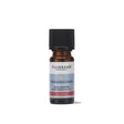 A small amber glass bottle of Tisserand Frankincense wild crafted pure essential oil with a light blue and white label and a black cap.