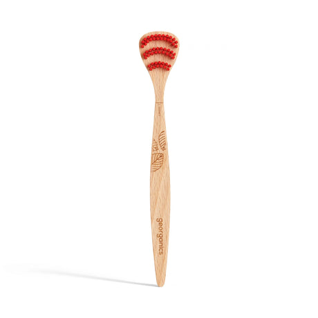 Wooden toothbrush with red bristles, featuring a carved leaf design on the handle. Branding text "georganics" is visible, conveying an eco-friendly vibe.