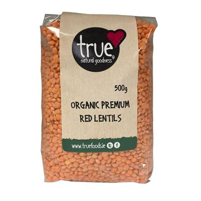 A 500g bag of True Natural Goodness Organic Premium Red Lentils, showing the orange-red lentils through a clear plastic pouch with a kraft paper label.