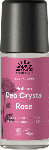 A glass roll-on deodorant bottle with a pink label featuring a rose illustration, Urtekram branding, and organic and vegan certifications.