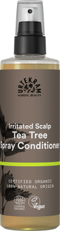 A brown spray bottle of Urtekram Tea Tree Spray Conditioner for irritated scalp, featuring plant illustrations, a lime green stripe, and organic and vegan logos.