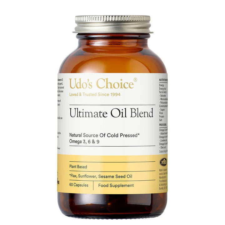 A dark amber glass bottle of Udo's Choice Ultimate Oil Blend food supplement capsules with a white and yellow label and a silver metal cap.