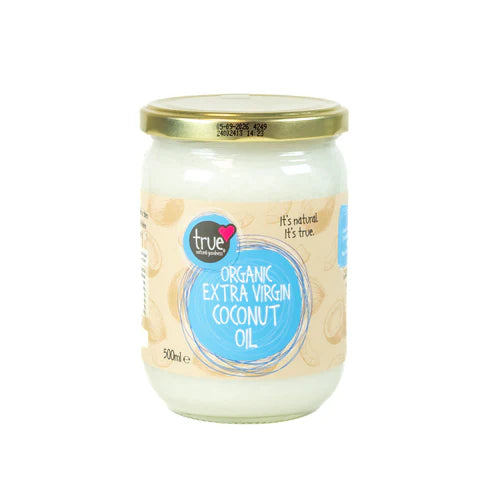 A 500ml glass jar of solid white True Organic Extra Virgin Coconut Oil with a light beige label, blue circular branding, and a gold metal lid.
