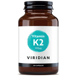 A 60-capsule amber glass jar of Viridian Vitamin K2 100µg food supplement with a white label and a turquoise watercolor-style circle, isolated on a white background.