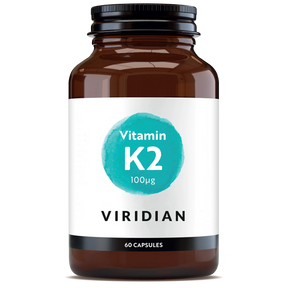 A 60-capsule amber glass jar of Viridian Vitamin K2 100µg food supplement with a white label and a turquoise watercolor-style circle, isolated on a white background.