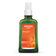 A green glass pump bottle of Weleda Sport Massage Oil with Arnica, featuring an orange label with yellow flower illustrations.