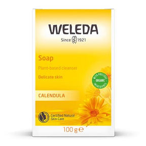 A yellow box of Weleda Calendula Soap, described as a plant-based cleanser for delicate skin, featuring orange calendula flower illustrations.