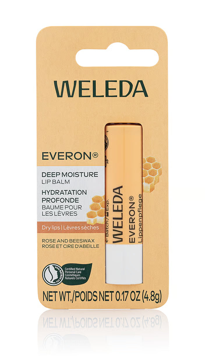 A single stick of Weleda Everon Deep Moisture Lip Balm in cardboard blister packaging, featuring rose and beeswax ingredients with a honeycomb illustration.