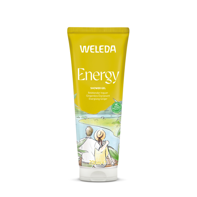 A yellow 200ml tube of Weleda Energy Shower Gel with "Energising Ginger" text and an illustration of a couple overlooking a serene lake landscape.