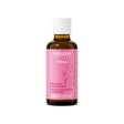 A brown glass bottle of Weleda Mama Perineum Massage Oil with a pink label featuring an illustration of a pregnant woman.