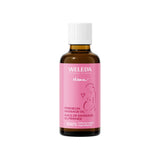 A brown glass bottle of Weleda Mama Perineum Massage Oil with a pink label featuring an illustration of a pregnant woman.