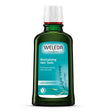 A dark green glass bottle of Weleda Revitalising Hair Tonic with Rosemary, designed to promote a healthy hair and scalp, featuring a light blue label and white cap.