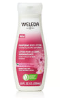 A white bottle of Weleda Pampering Body Lotion with wild rose extracts, featuring a pink label with floral illustrations, designed for normal to dry skin.