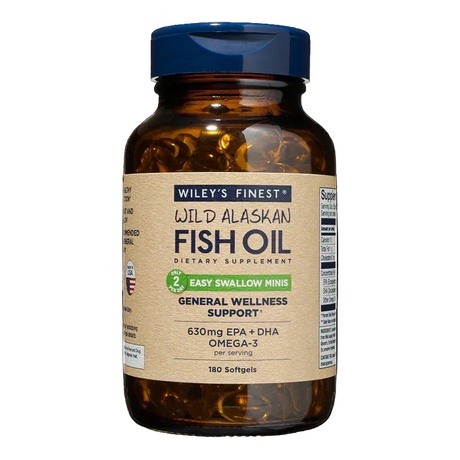 An amber glass bottle of Wiley's Finest Wild Alaskan Fish Oil "Easy Swallow Minis" dietary supplement, containing 180 softgels for general wellness support, featuring a blue flip-top cap and a tan label stating 630mg EPA + DHA per serving.