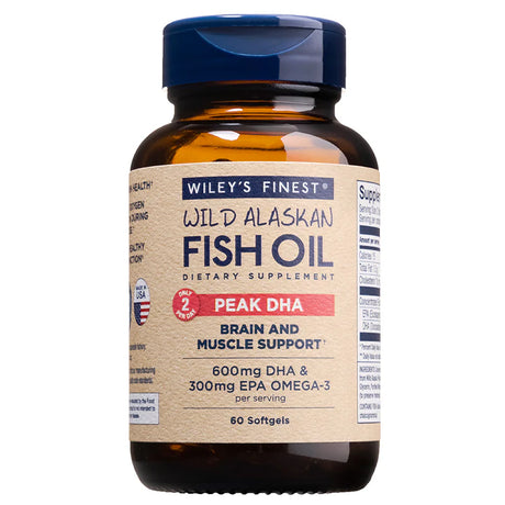 An amber glass bottle of Wiley's Finest Wild Alaskan Fish Oil Peak DHA dietary supplement, featuring a tan label with a red "Peak DHA" banner and text highlighting 600mg DHA and 300mg EPA for brain and muscle support.