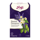 A box of Yogi Organic Sweet Dreams herbal tea blend, featuring a deep purple background with illustrations of lavender, chamomile, and hops alongside white daisies. The Yogi brand logo is clearly visible at the top.