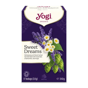 A box of Yogi Organic Sweet Dreams herbal tea blend, featuring a deep purple background with illustrations of lavender, chamomile, and hops alongside white daisies. The Yogi brand logo is clearly visible at the top.