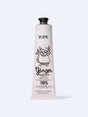 A light pink tube of YOPE Ginger & Sandalwood natural hand cream featuring an illustration of an owl, labelled as 98% low-processed ingredients of natural origin.