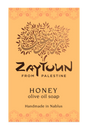 A rectangular soap bar label or packaging card for Zaytoun Honey Olive Oil Soap, featuring a warm orange background with a stylized olive tree logo and text reading 'Zaytoun From Palestine' and 'Honey olive oil soap Handmade in Nablus'.