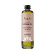 Bottle of Fushi organic argan oil on a light background. Label is soft pink with black text and white flower graphic, conveying a natural, nourishing tone.