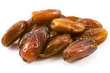 Close-up view of a small heap of plump, naturally dried dates isolated on a white background.