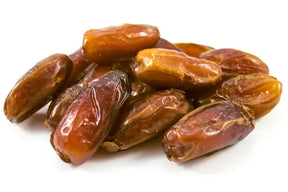 Close-up view of a small heap of plump, naturally dried dates isolated on a white background.