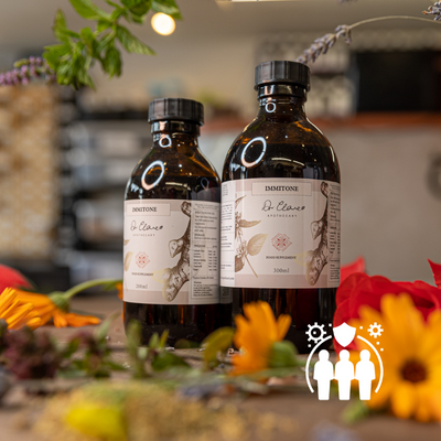 Two bottles of Damtoño on a table with flowers and blurred background