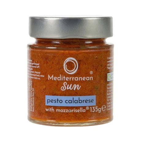 Jar of Mediterranean Sun Pesto Calabrese with Mozzarisella, featuring a bright orange sauce. The label is elegant and simple, creating a gourmet feel.