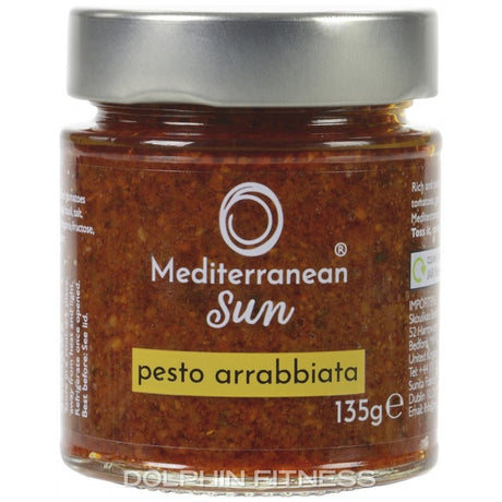 Jar of Mediterranean Sun pesto arrabbiata with a silver lid. The label is white with a yellow band, and the pesto is a rich red color.